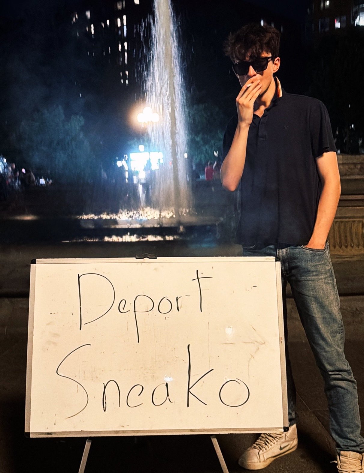 Image in @sneako's post: Dude you look EPIC smoking a CIGARETTE behind a WHITEBOARD that says DEPORT SNEAKO in marker 🔥 http…