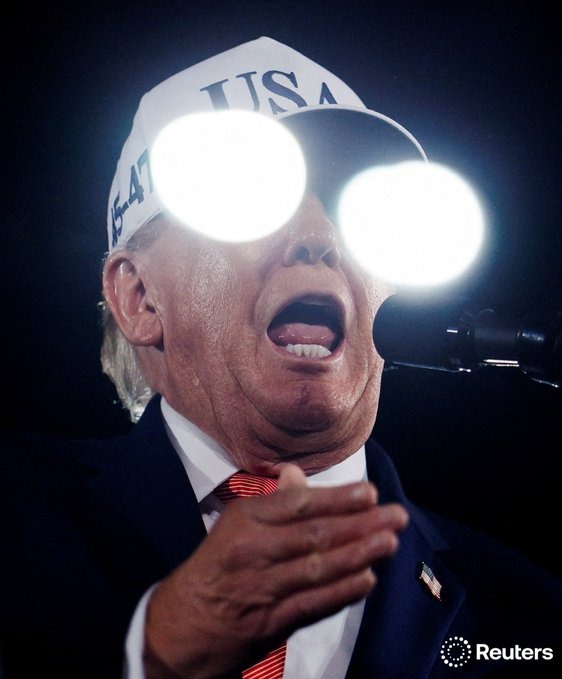 Image in @MarioNawfal's post: 🇺🇸 Laser eyes, but make it MAGA 😆
Stage lights bounced off the bulletproof glass in front of Trump…